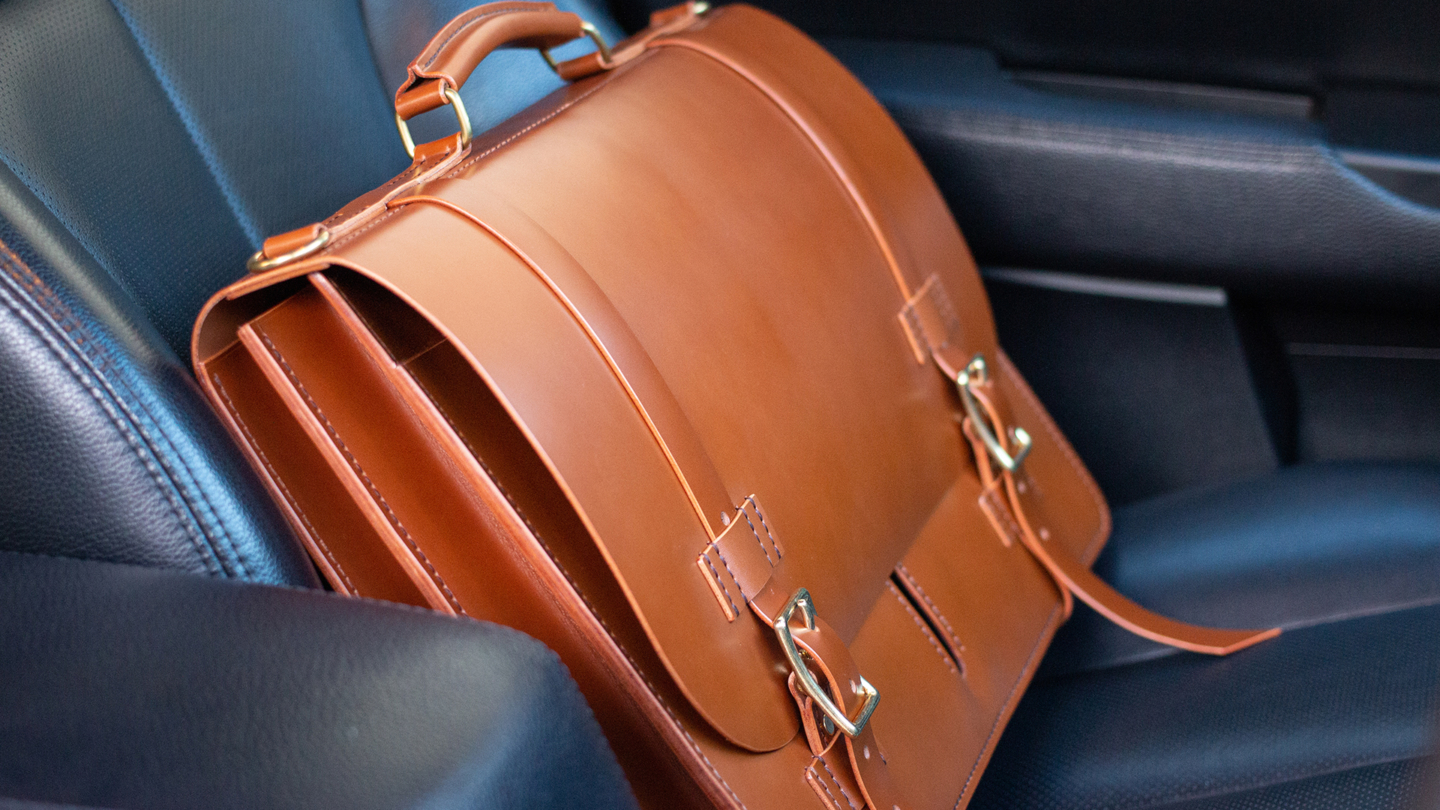 Brown leather briefcase sitting in the seat of a car