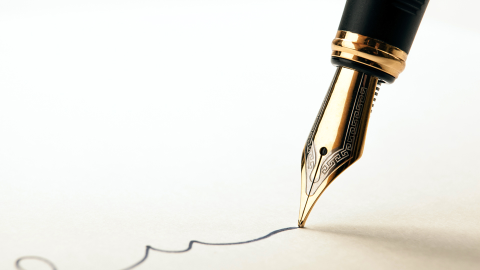 A fountain pen signing a legal document